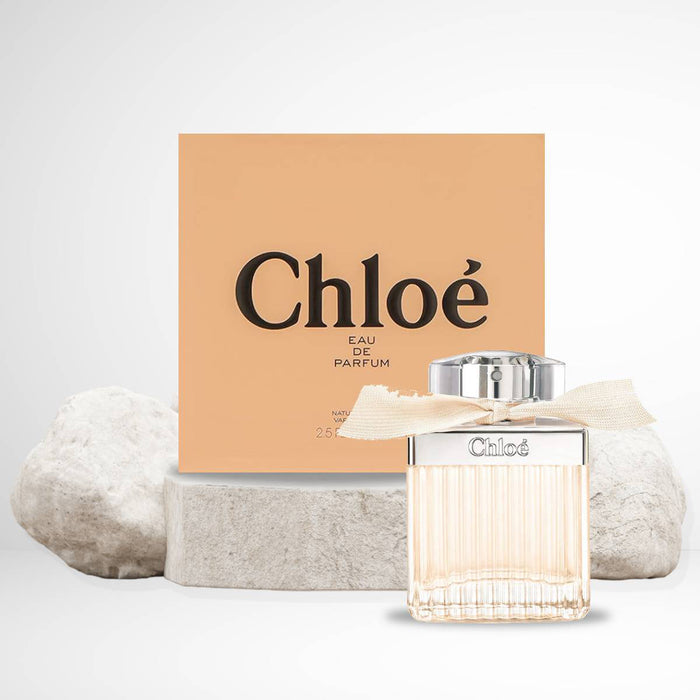 Chloe Eau de Parfum in clear square glass bottle with ridged texture, round flat chrome cover and pastle ribbon